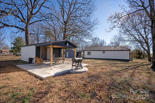 a view of a house with backyard and trees