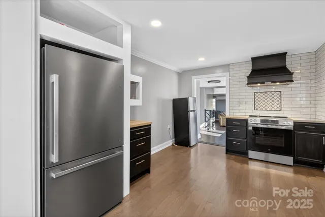 a kitchen with stainless steel appliances a refrigerator and a stove top oven