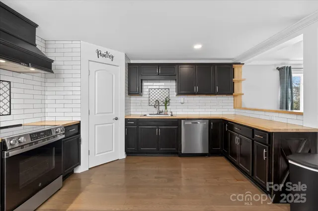 a kitchen with stainless steel appliances granite countertop a stove a sink and a microwave