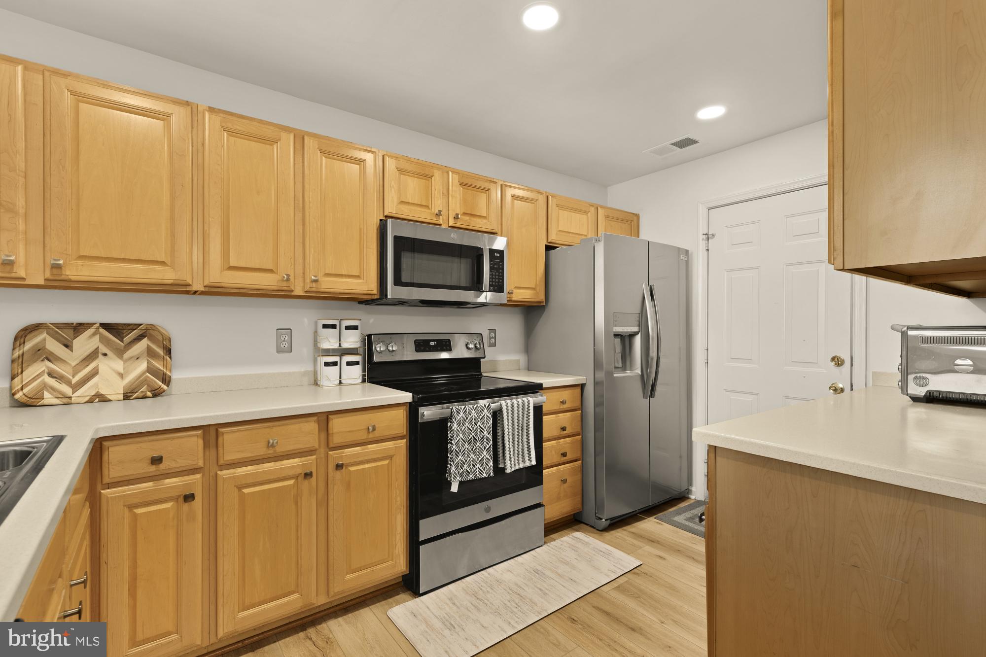 1887 Crescent Park Drive, Unit 111A Reston, VA 20190 - Photo 11 of 27 a kitchen with stainless steel appliances granite countertop a refrigerator stove and sink