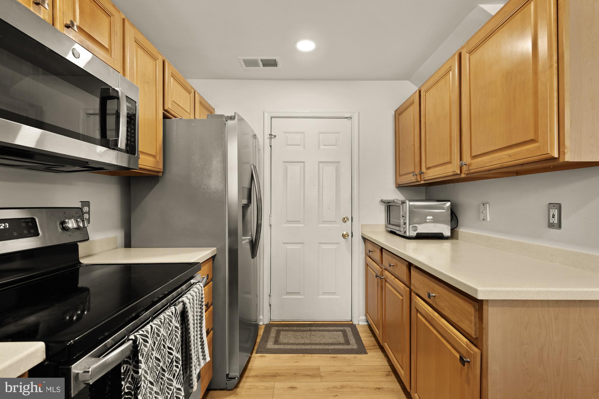 1887 Crescent Park Drive, Unit 111A Reston, VA 20190 - Photo 12 of 27 a kitchen with stainless steel appliances a sink a stove a refrigerator cabinets and a dining table