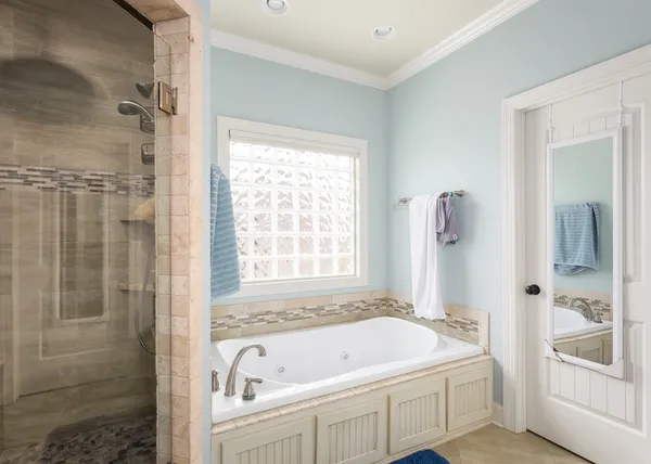 a bathroom with a tub a sink and a window