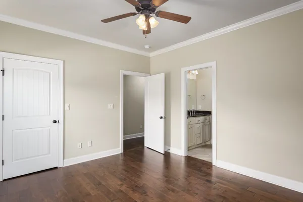 an empty room with wooden floor and ceiling fan