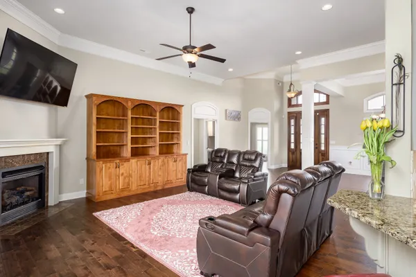 a living room with furniture a flat screen tv and a fireplace