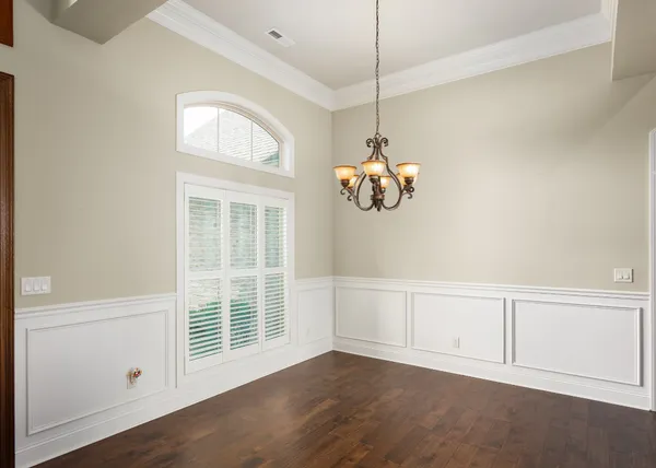 a view of an empty room with a window and chandelier