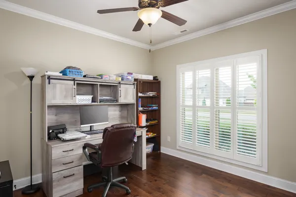 a view of a workspace with furniture and a window