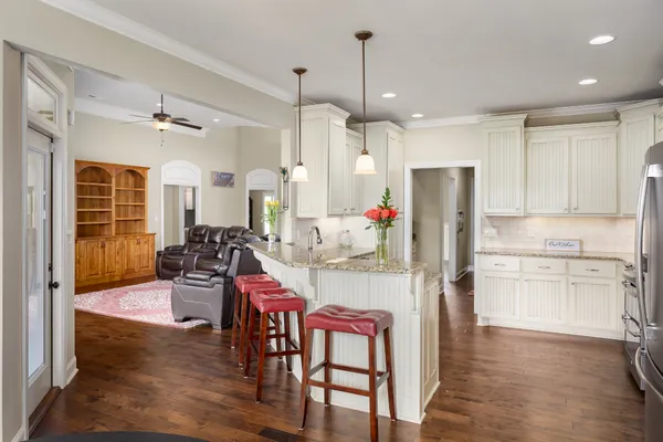 a kitchen with refrigerator and chairs