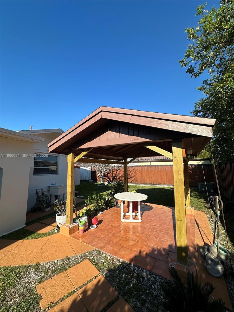 9814 Southwest 4th Terrace Miami, FL 33174 - Photo 10 of 10 a view of patio with table and chairs under an umbrella with large trees