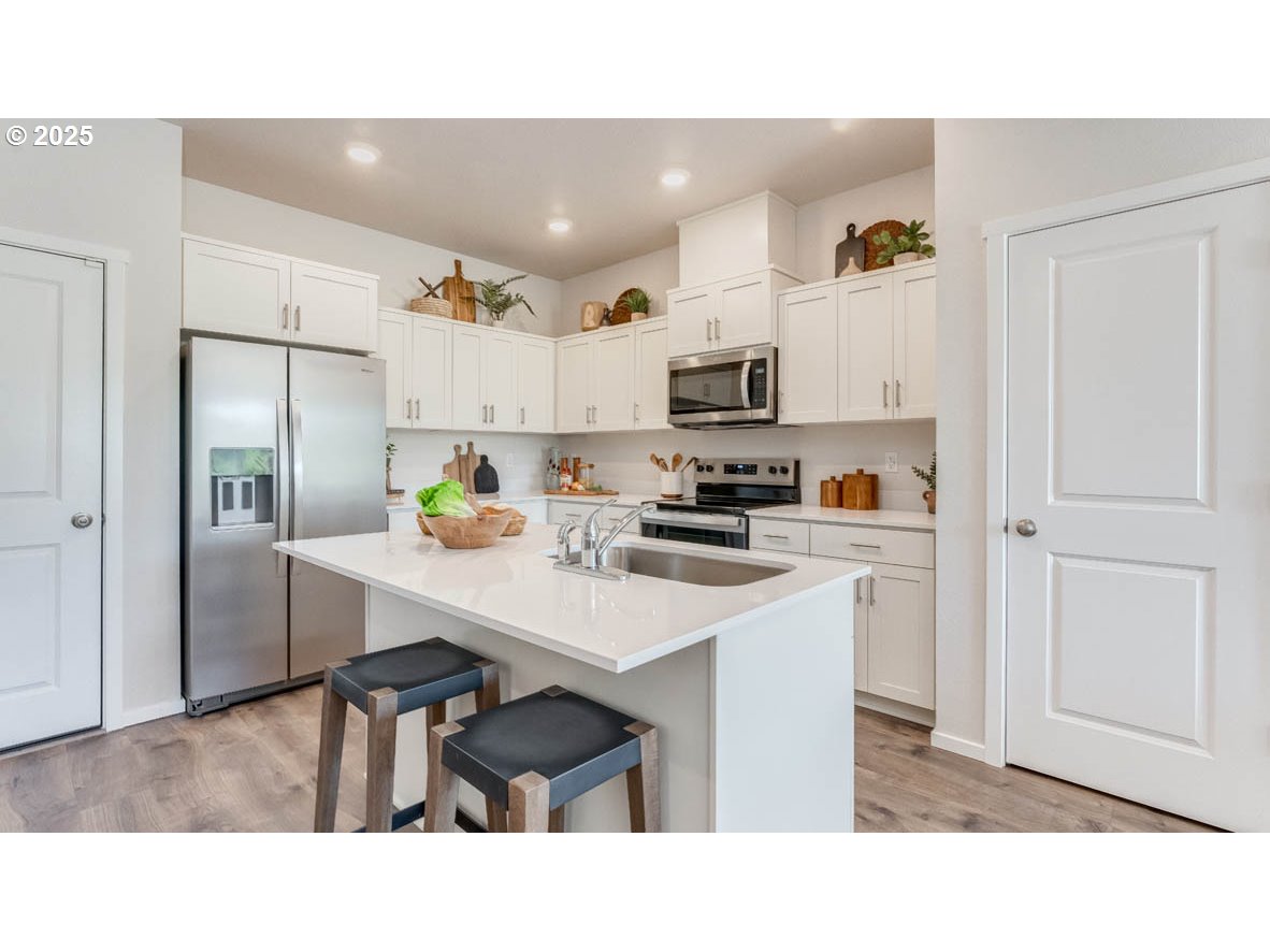 3441 Southwest Hartley Avenue Gresham, OR 97080 - Photo 8 of 28 a kitchen with kitchen island white cabinets and stainless steel appliances