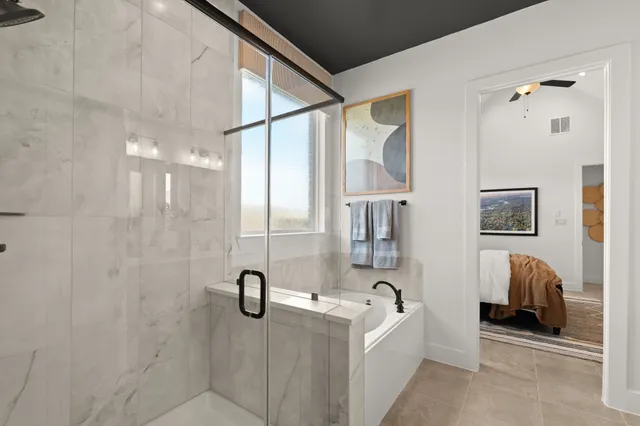 a bathroom with glass door shower and a bathtub