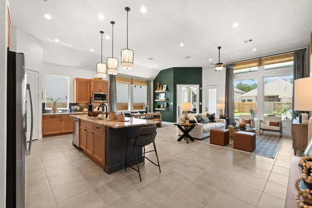 a large kitchen with a large counter top appliances and a living room view