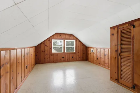 a view of an empty room with wooden floor and stairs