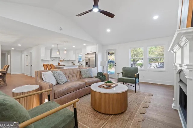 a living room with furniture kitchen view and a large window