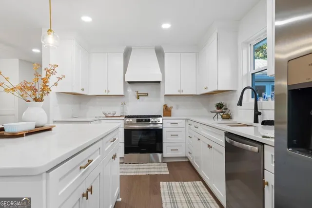 a kitchen with cabinets appliances a sink and a counter top space