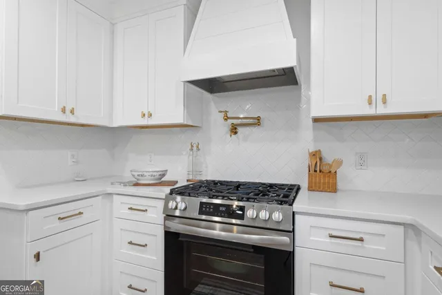 a kitchen with white cabinets and appliances