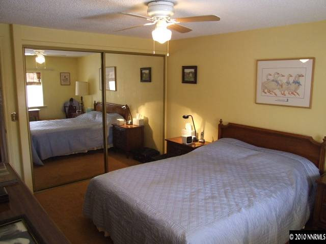 17485 Fantail Street Reno, NV 89508 - Photo 5 of 13 a bedroom with a bed and a chandelier