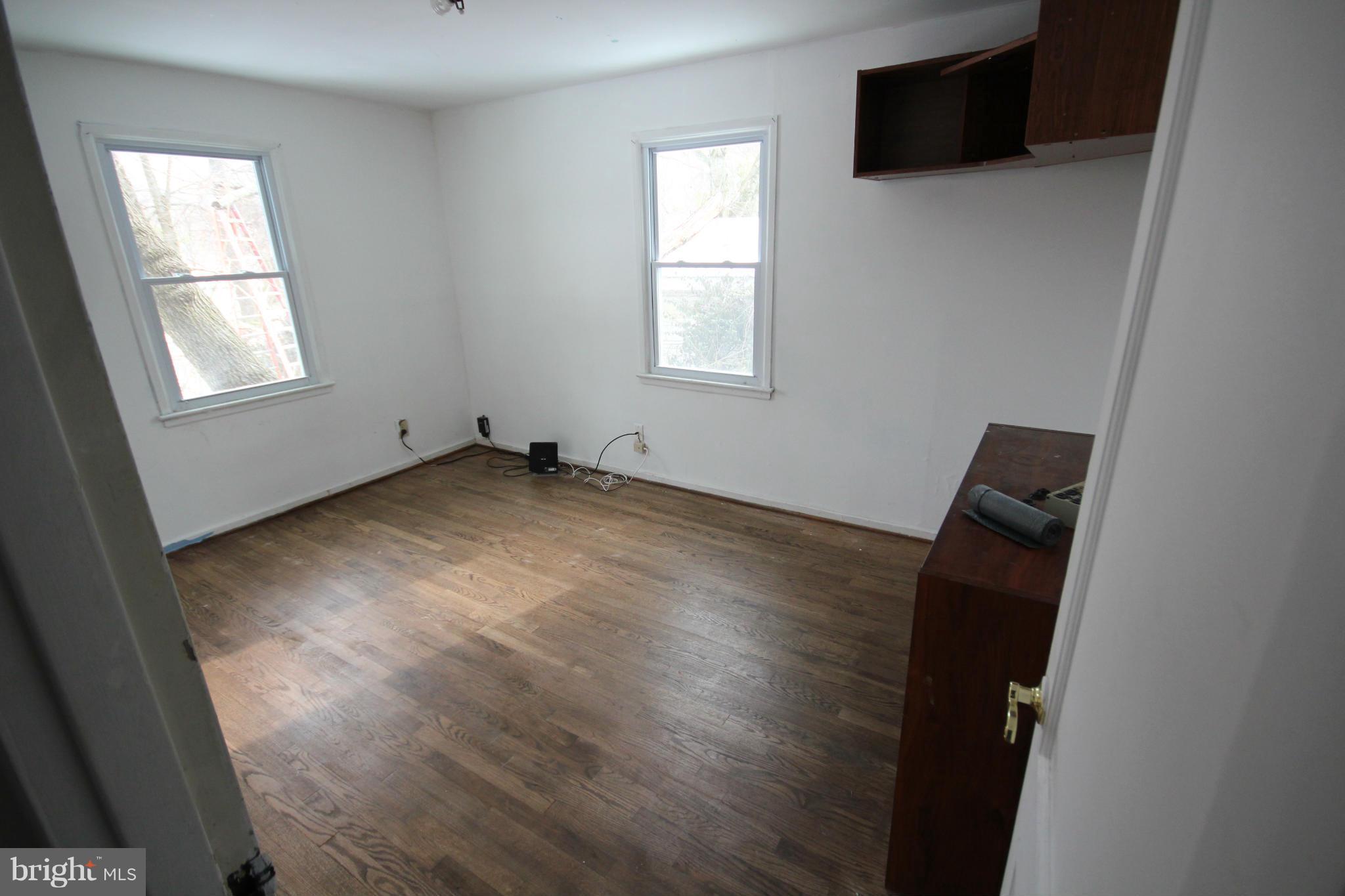 12305 Bluhill Road Silver Spring, MD 20902 - Photo 3 of 4 an empty room with wooden floor and windows