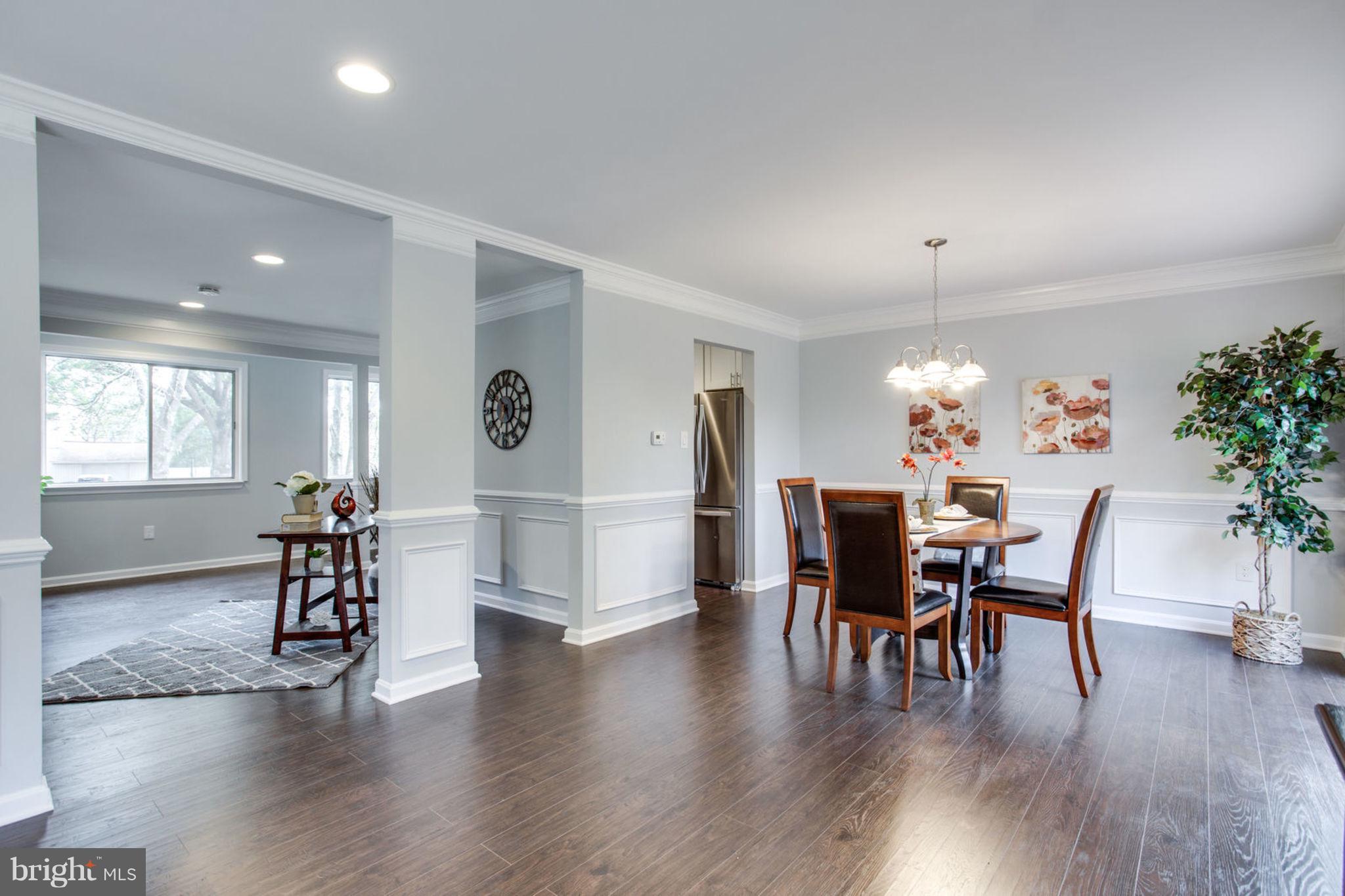 14312 Sturtevant Road Silver Spring, MD 20905 - Photo 13 of 43 a dining room with wooden floor a chandelier a glass table and chairs