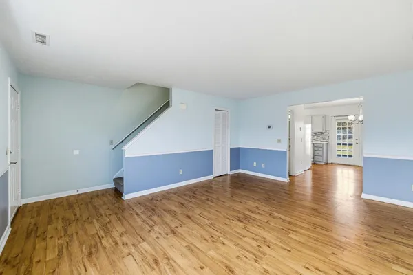a view of empty room with wooden floor