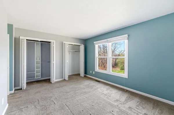 an empty room with windows and closet