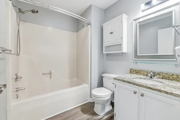 a bathroom with a granite countertop sink toilet and shower