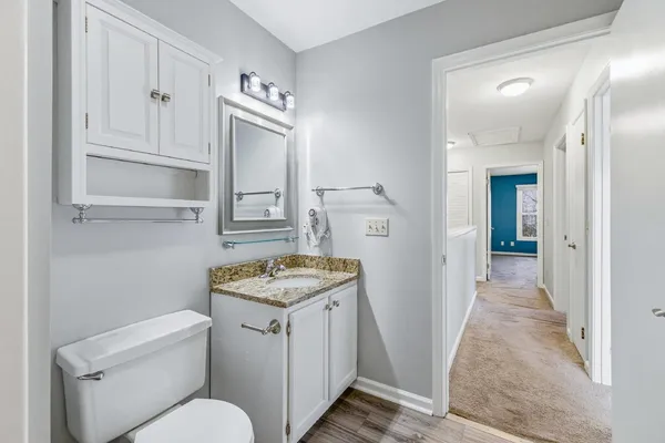a bathroom with a granite countertop toilet sink and mirror