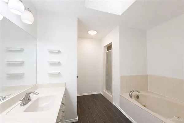 a bathroom with a tub sink and mirror