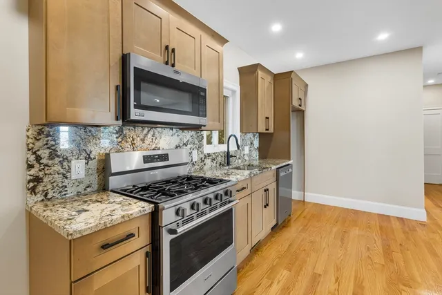 a kitchen with stainless steel appliances granite countertop a stove and a microwave