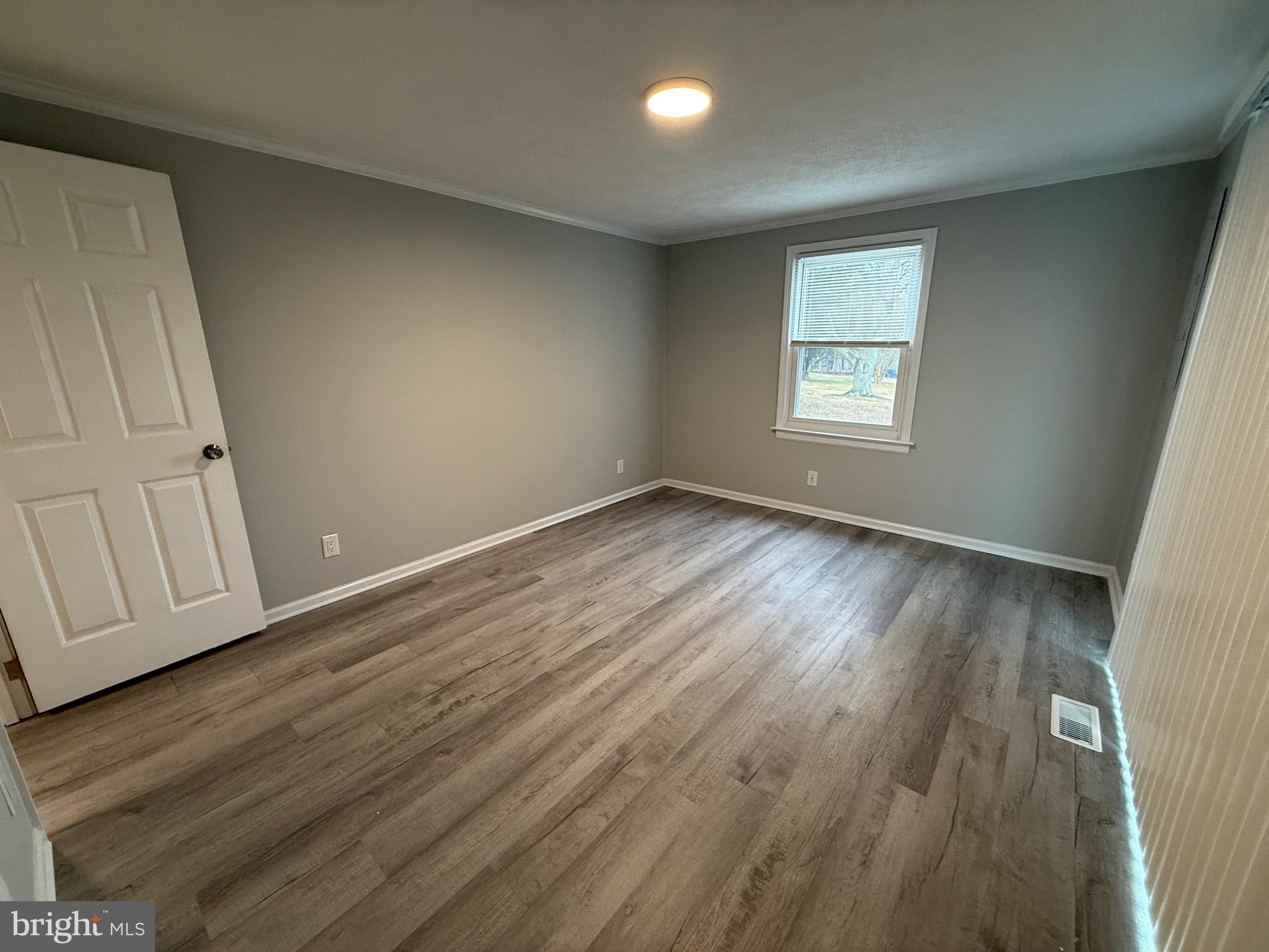 299 Blue Crab Loop Montross, VA 22520 - Photo 23 of 30 an empty room with wooden floor and windows