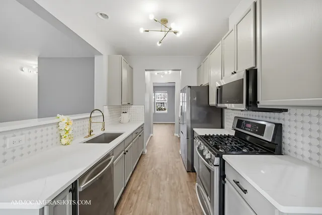 a kitchen with stainless steel appliances a sink stove and refrigerator