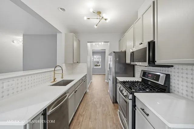 a kitchen with stainless steel appliances a sink stove and refrigerator