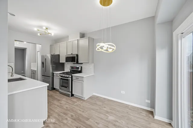 a kitchen with stainless steel appliances granite countertop a stove top oven a sink and a refrigerator