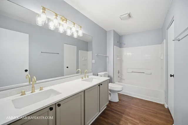 a bathroom with a double vanity sink mirror and toilet