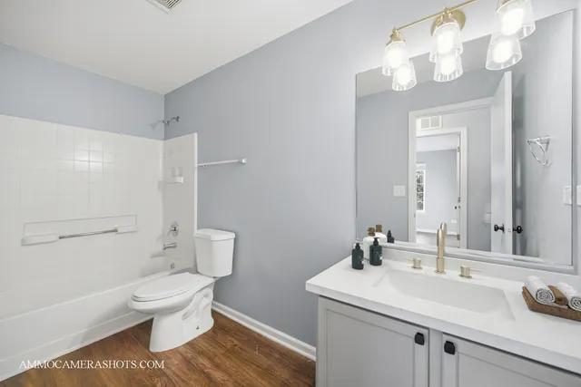 a bathroom with a sink a toilet and a large mirror