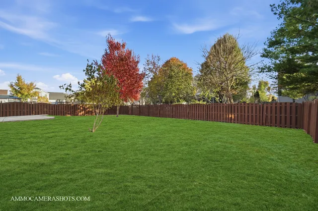 a view of yard with green space and wooden fence