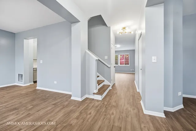 a view of a hallway with wooden floor and staircase