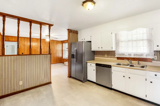 a kitchen that has a lot of cabinets and wooden floor