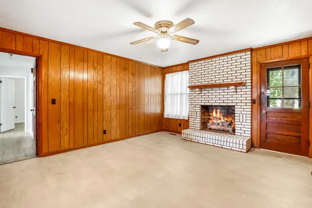 an empty room with windows and fireplace
