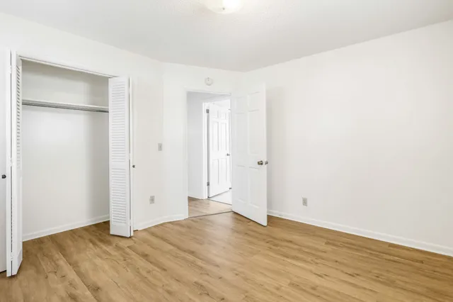 a view of an empty room with wooden floor