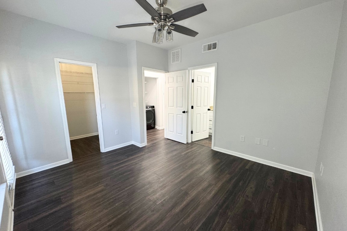 11203 Ranch Road 2222, Unit 2203 Austin, TX 78730 - Photo 12 of 34 an empty room with wooden floor fan and windows