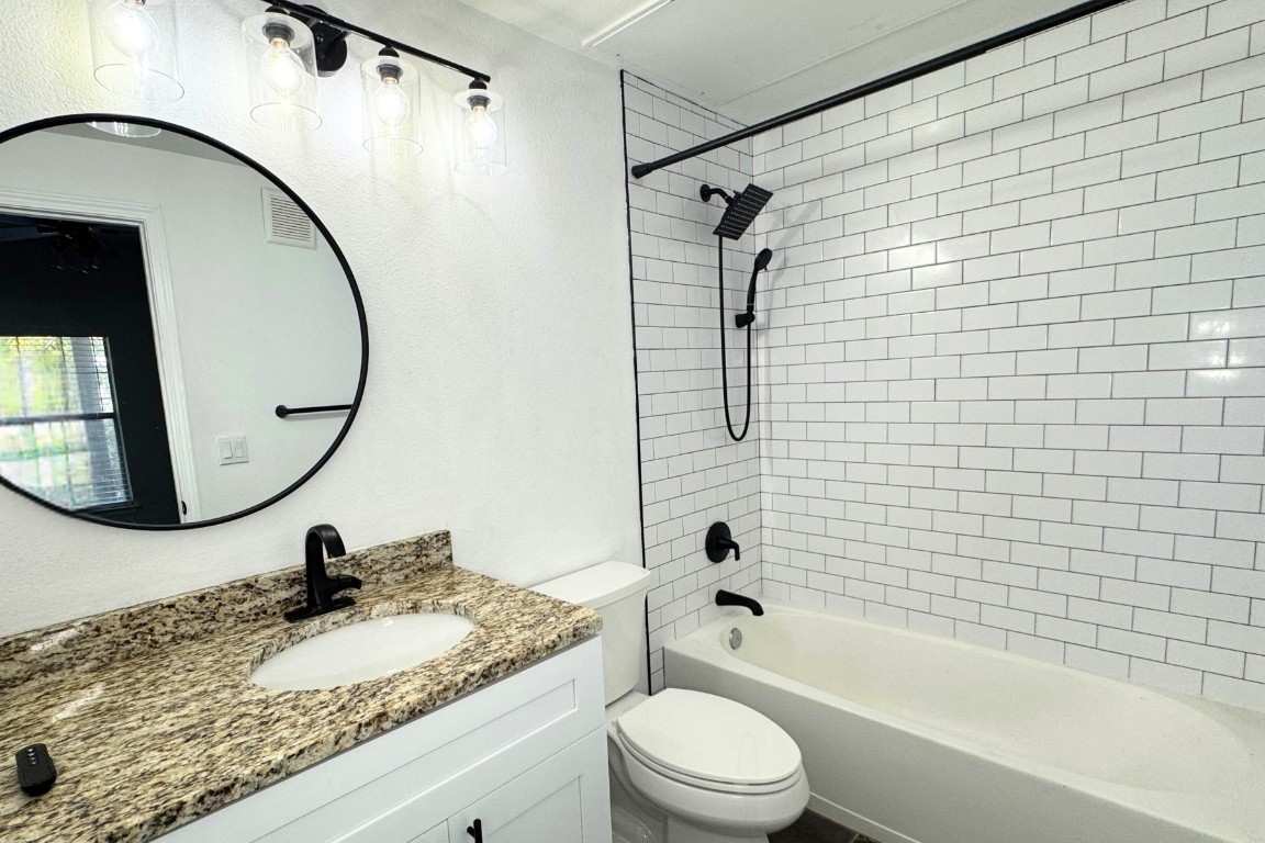 11203 Ranch Road 2222, Unit 2203 Austin, TX 78730 - Photo 14 of 34 a bathroom with a granite countertop sink a toilet and a mirror