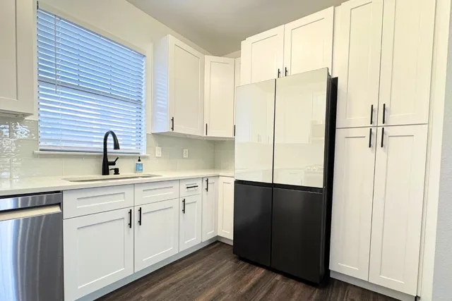 a kitchen with a sink a refrigerator and cabinets