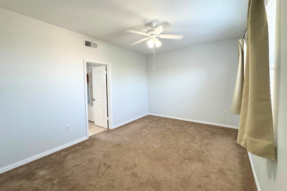 11203 Ranch Road 2222, Unit 2203 Austin, TX 78730 - Photo 24 of 34 an empty room with a chandelier fan and windows