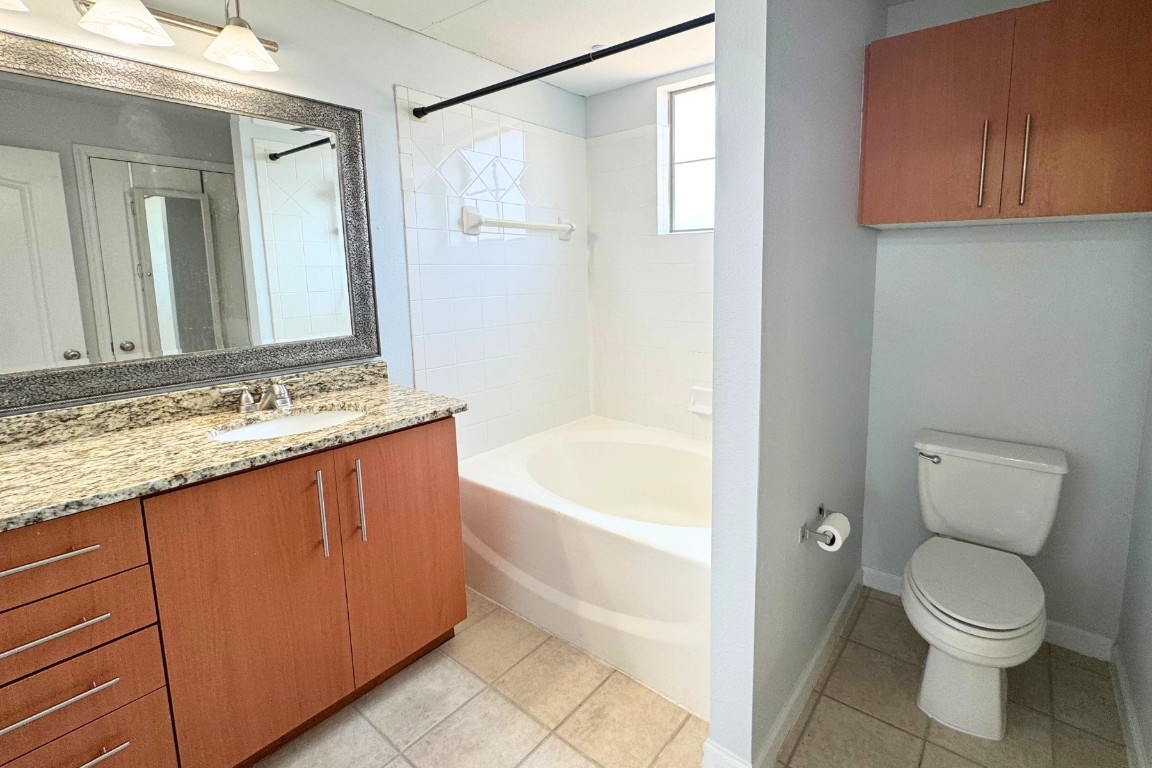 11203 Ranch Road 2222, Unit 2203 Austin, TX 78730 - Photo 25 of 34 a bathroom with a granite countertop sink a toilet and bathtub