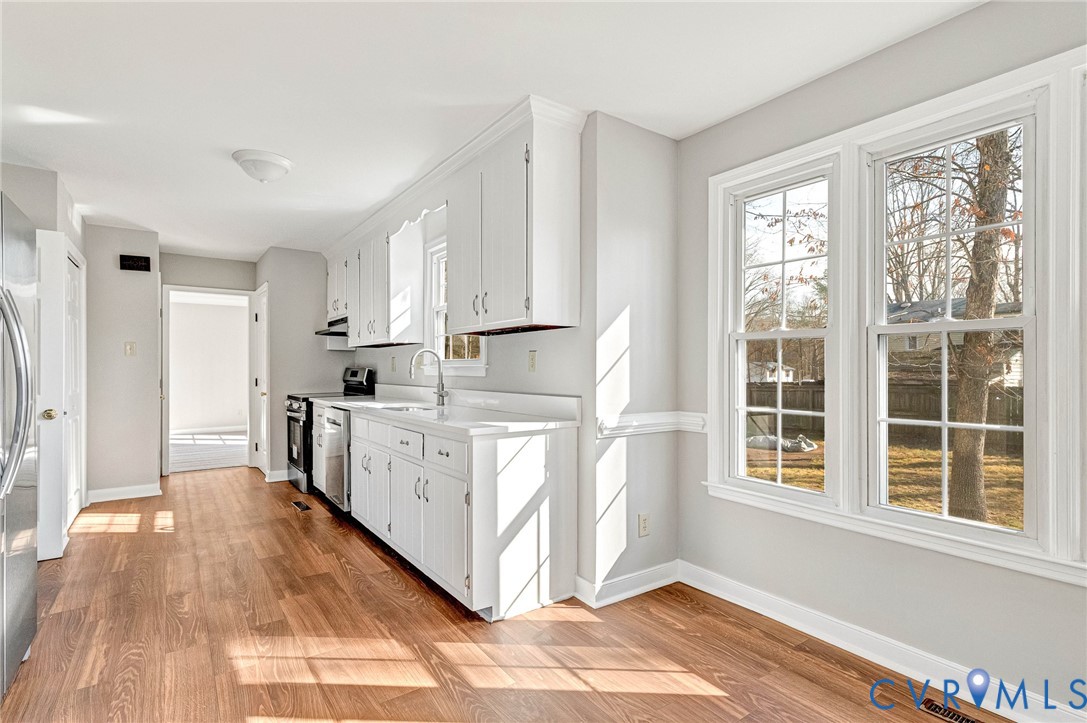 2139 Esquire Road North Chesterfield, VA 23235 - Photo 3 of 35 a kitchen with white cabinets and wooden floor