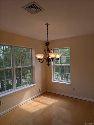a view of wooden floor cabinets and a window in an empty room