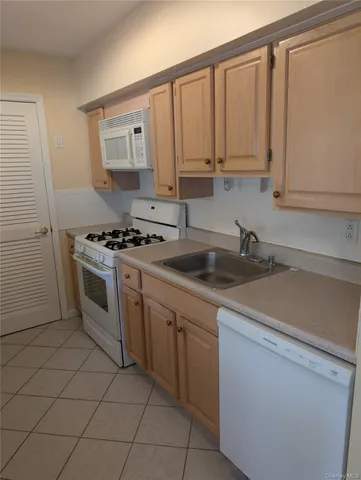 a kitchen with white cabinets and white appliances