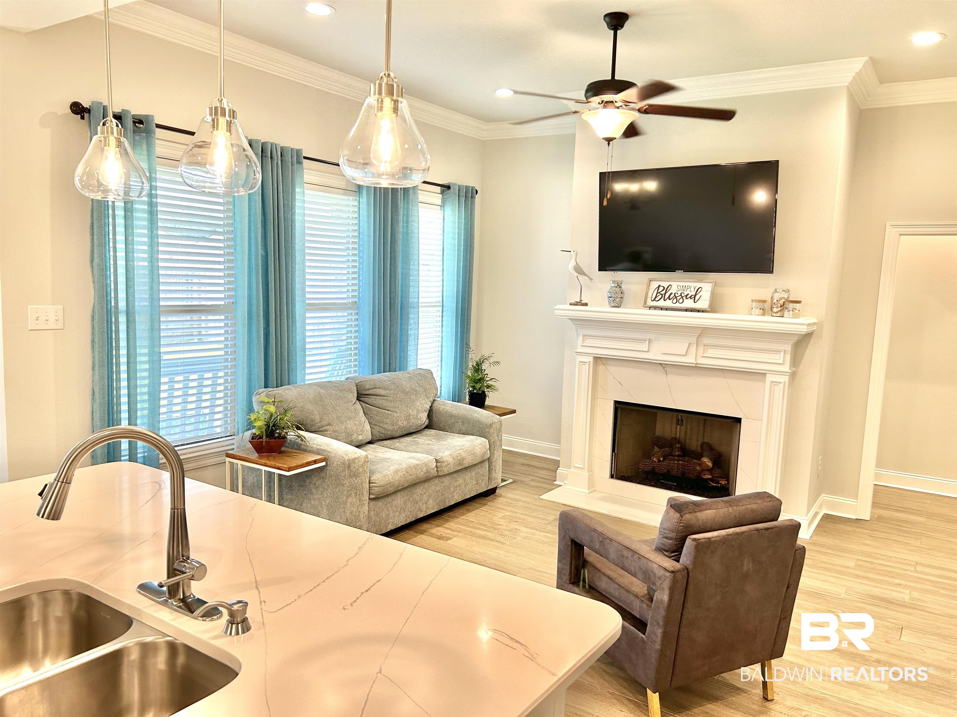 1398 Aldon Street Foley, AL 36535 - Photo 31 of 32 Living room featuring crown molding, light wood-look tile flooring, ceiling fan, and fireplace