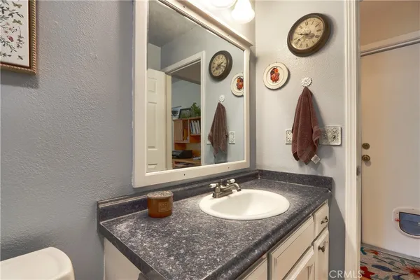 a bathroom with a granite countertop toilet sink and mirror