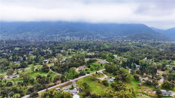 an aerial view of house with yard and mountain view in back
